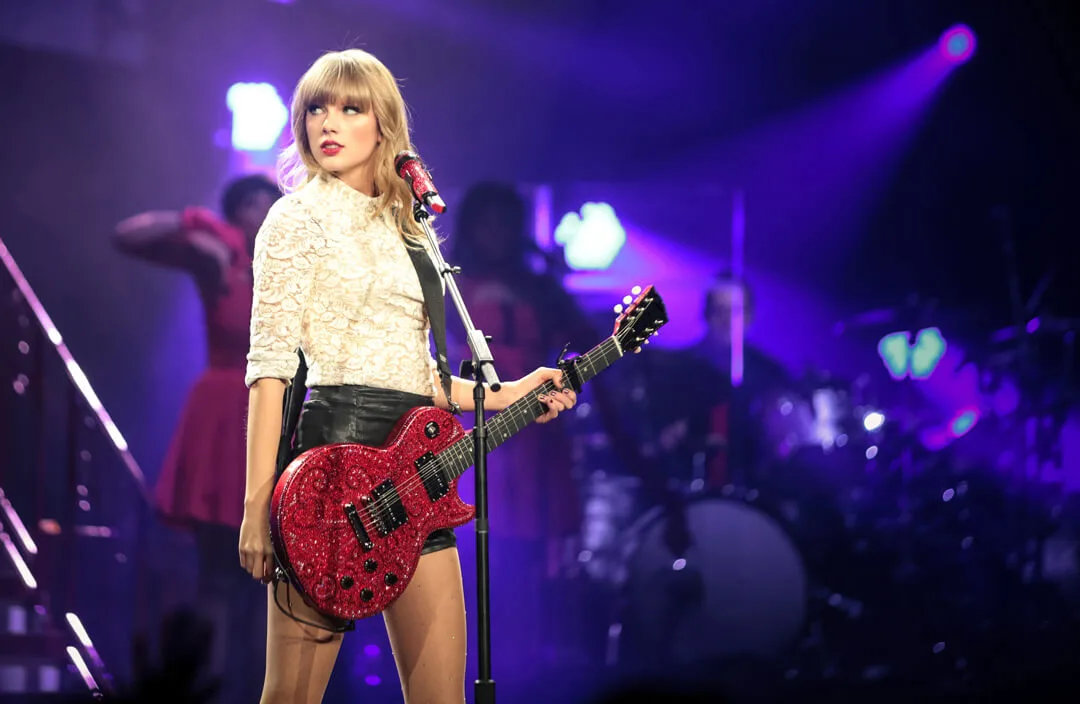 A red guitar in a brighter stage setting